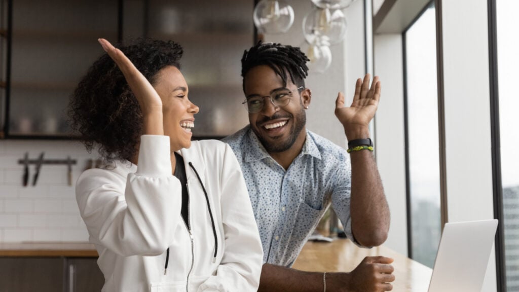 black couple high five business computer work at home - shutterstock fizkes