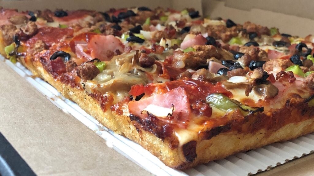 A Detroit-style pizza with a lot of toppings on it.