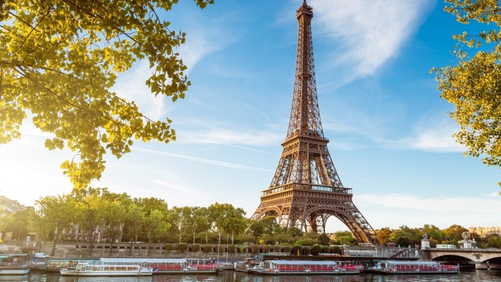 The Eiffel Tower on the banks of the River Seine in Paris, France on a sunny day.