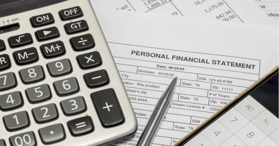 photo of calculator sitting on a document titled personal financial statement