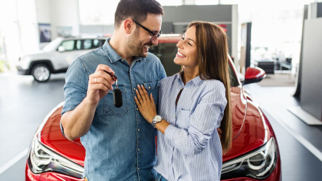 couple buying new car at car dealership