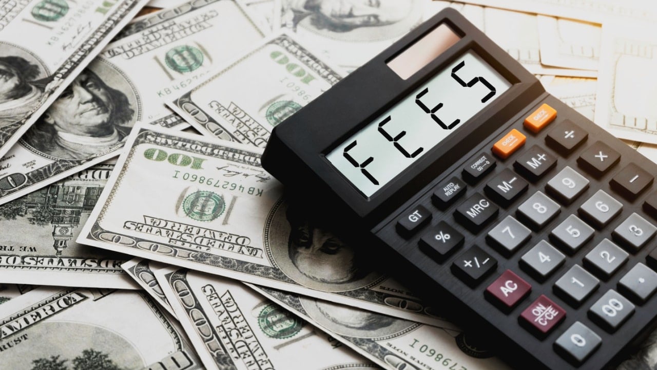 Calculator with the word FEES on the calculator placed on the dollar, concepts, fees, fees services and taxes.