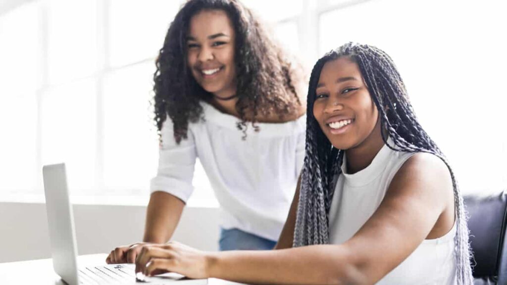 Online Jobs for Teens: Two Happy teen taking a break at desk in her office