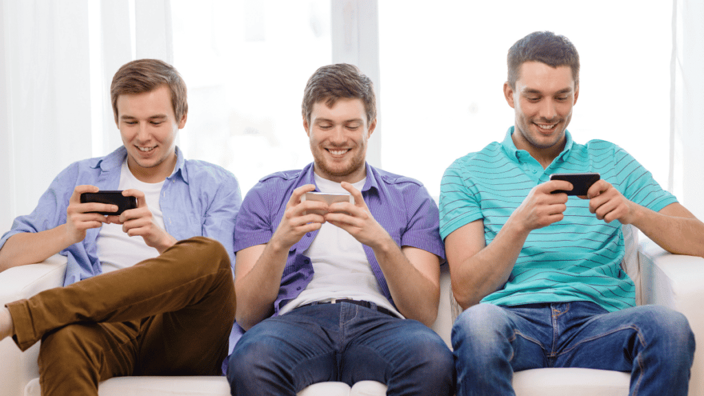 3 guys playing games on their phones