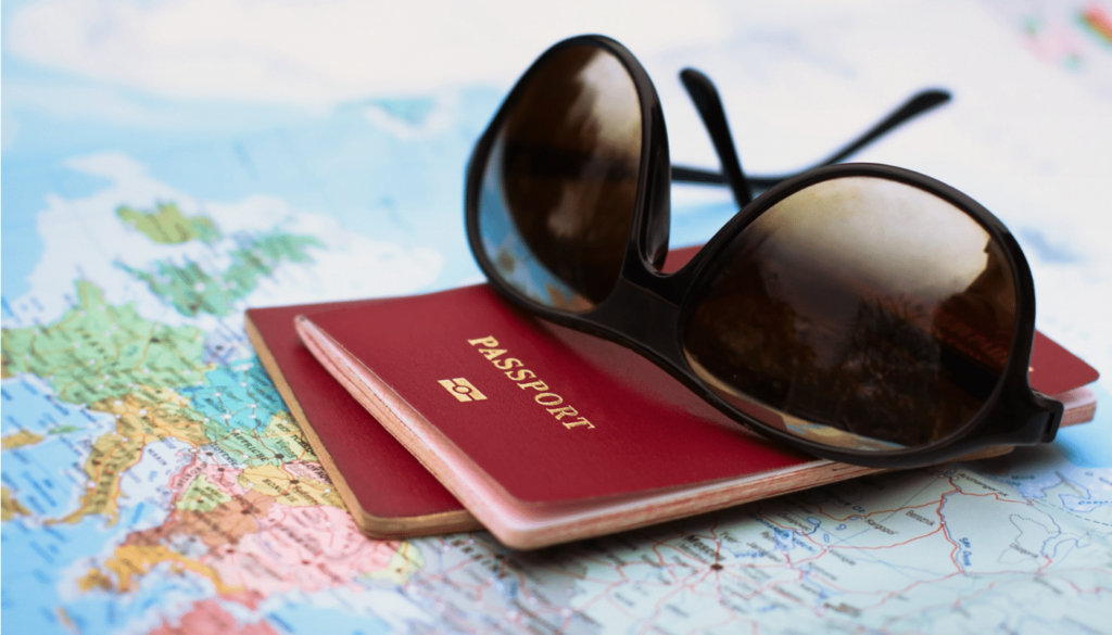 Vacation Packages - photo of sunglasses sitting on passports sitting on a world map